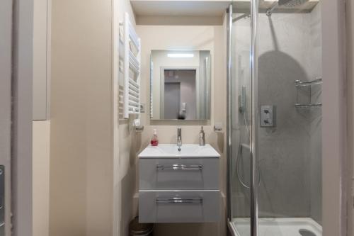 une salle de bain blanche avec un lavabo et une douche dans l'établissement Apartment with parking on Place de Morny, à Deauville