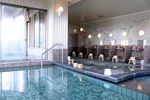 a pool in a hotel lobby with a bar at Resort Hills Toyohama Soranokaze in Toba