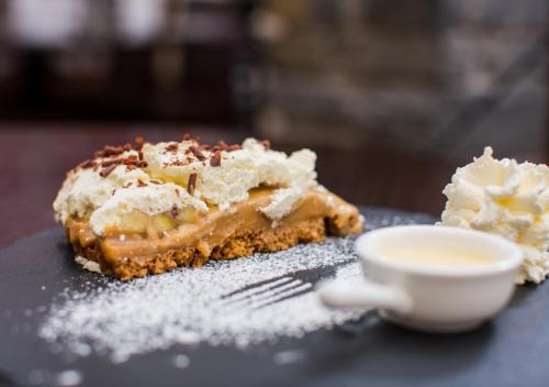 a piece of pie with a fork and a cup of coffee at Castle Hotel Macroom in Macroom