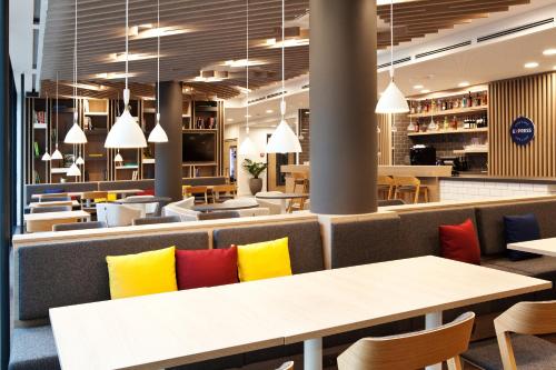 a restaurant with yellow and red pillows on tables at Holiday Inn Express - Mülheim - Ruhr by IHG in Mülheim an der Ruhr