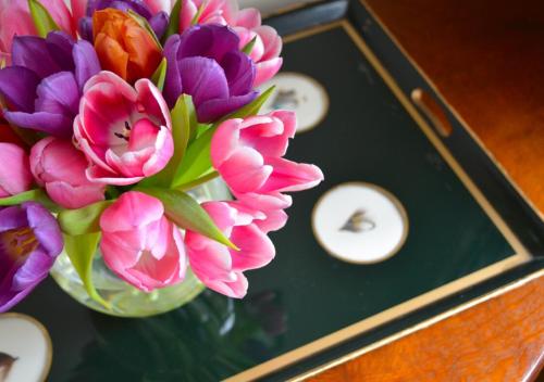 a vase filled with flowers on a table with clocks at Delphi Lodge in Leenaun