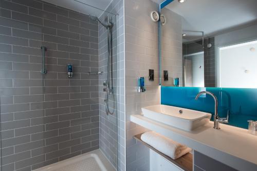 y baño con lavabo, bañera y espejo. en Holiday Inn Express Portsmouth – North, an IHG Hotel en Portsmouth