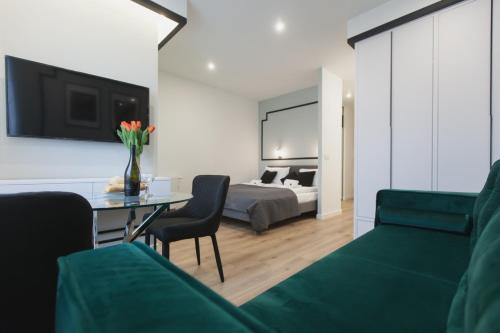 Una sala de estar con una cama, una mesa y sillas. en City Break Atelier Praga Apartamenty, en Varsovia