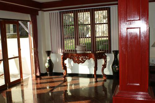 a room with a table and two windows at Prince Edouard Apartments & Resort Patong Beach Phuket in Patong Beach