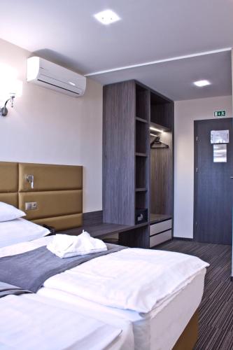 a hotel room with two beds and a closet at Relax Panzió in Győr