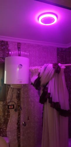 a bathroom with a purple lighting and a shower curtain at mody appartment at alexandria in Alexandria