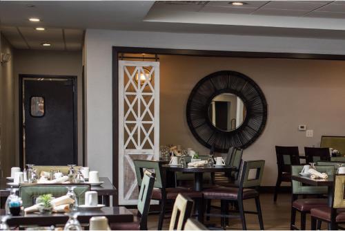 a dining room with tables and chairs and a mirror at Holiday Inn Harrisburg East by IHG in Middletown