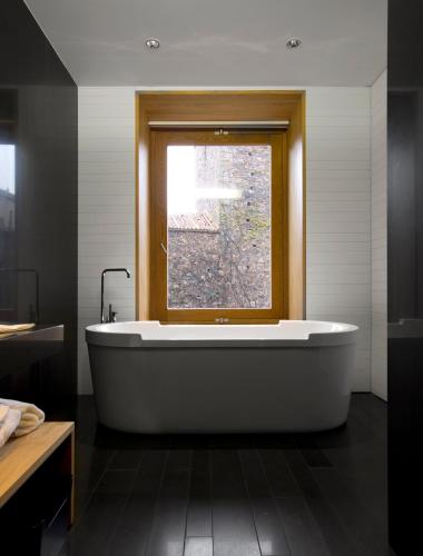 a bath tub in a bathroom with a window at Atrio in Cáceres