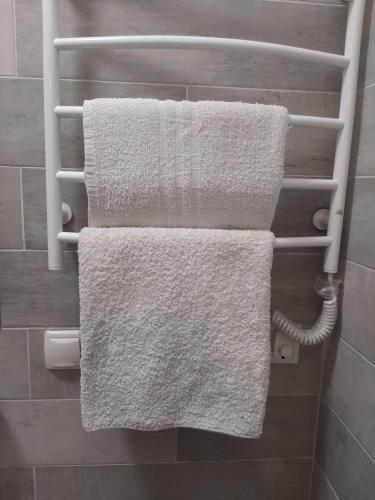 two white towels hanging on a towel rack in a bathroom at sweet home in Ivano-Frankivsʼk