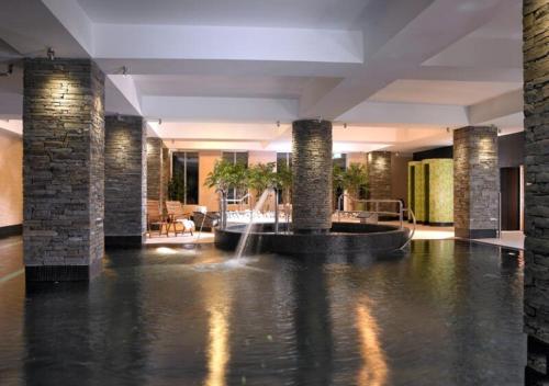 
a large swimming pool in a building with a fountain at Garryvoe Hotel in Ballycotton
