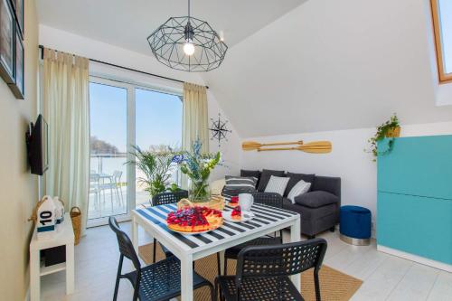 a living room with a table and chairs and a couch at Apartamenty Bałtyckie in Lubiatowo