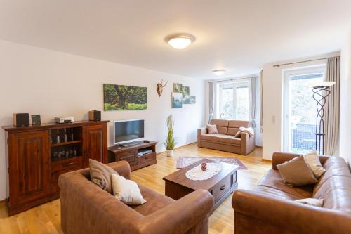 a living room with two couches and a tv at Ferienwohnung an der Salamanderburg in Schierke