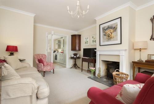 a living room with a couch and a fireplace at Fairfields in Moreton in Marsh