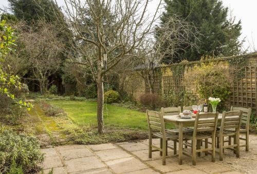 a wooden table with chairs sitting on a patio at Fairfields in Moreton in Marsh