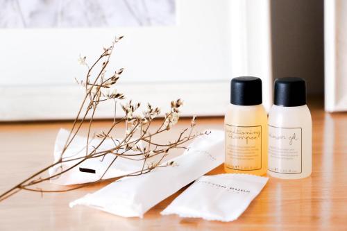 two bottles of products sitting on a table with flowers at Tonkla Boutique Hotel in Lamphun