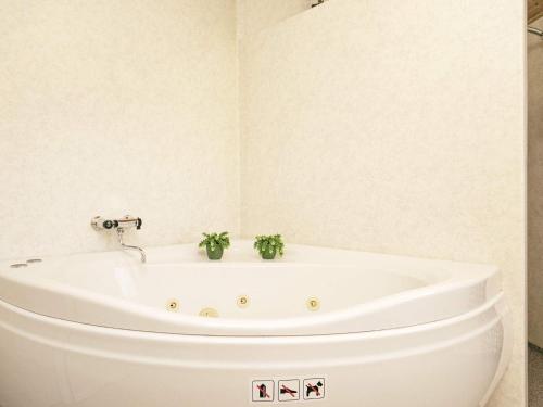 a bathroom with a bath tub with two plants in it at 8 person holiday home in Ringk bing in Nørby