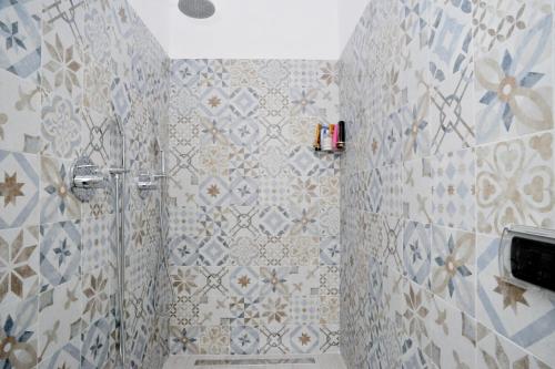 a bathroom with a shower with a tiled wall at Guest House La Genesa in Cernobbio
