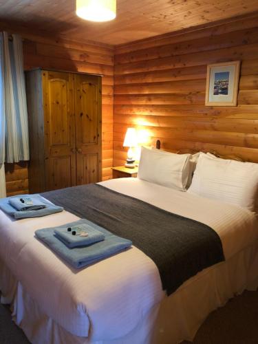 - une chambre avec un grand lit dans une cabane en rondins dans l'établissement East Crinnis Log Cabin, à Par