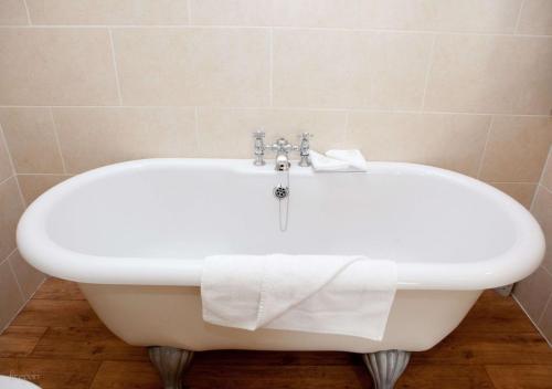 a white bath tub with a towel on top of it at Headfort Arms Hotel in Kells