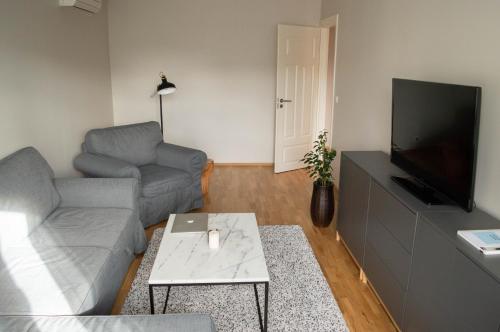 a living room with a couch and a flat screen tv at Modern apartment in the heart of Kärdla in Kärdla