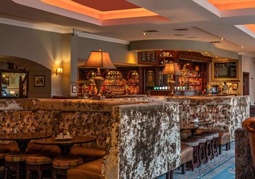 a bar with tables and stools in a restaurant at Headfort Arms Hotel in Kells