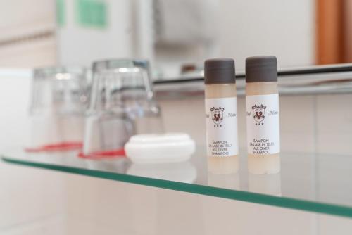 two bottles of moisturizers sitting on a glass shelf at Hotel Medno in Ljubljana
