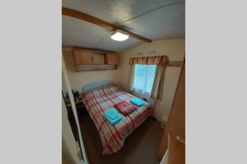 Cette petite chambre comprend un lit et une fenêtre. dans l'établissement Kimberley Lane Static, Cornwall, à Gwennap