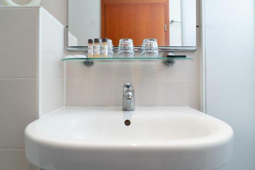 a bathroom sink with a mirror and soap dispenser at Hotel Medno in Ljubljana
