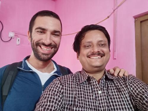 two men posing for a picture in front of a pink wall at Green Homestay Kolkata - Prefer International Guest - Attach Bath - Paid Kitchen in Kolkata