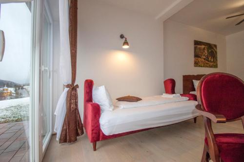 a room with a bed and chairs and a window at Dwór i Dworek Leszczowate Wellness & Spa in Ustrzyki Dolne