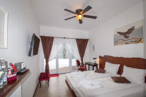 a bedroom with a bed and a ceiling fan at Dwór i Dworek Leszczowate Wellness & Spa in Ustrzyki Dolne