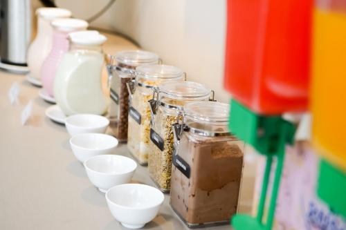 a row of jars and white bowls on a table at Das Nações Hotel in Florianópolis