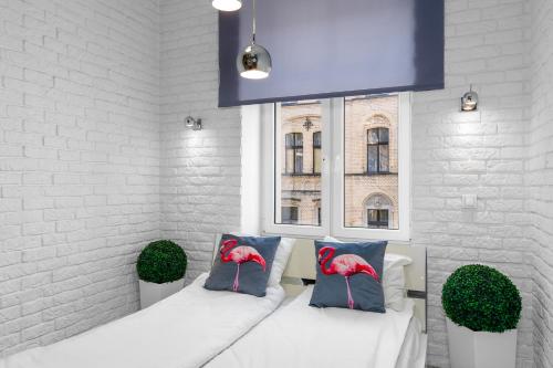 ポズナンにあるSleepway Apartments - Grey Dreamのソファ、枕、窓が備わる客室です。