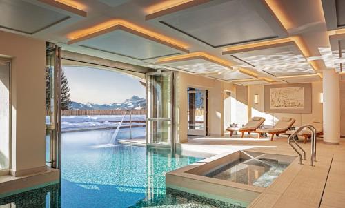a swimming pool with a tub in a house at Les Chalets du Mont d'Arbois & Spa, Megève in Megève