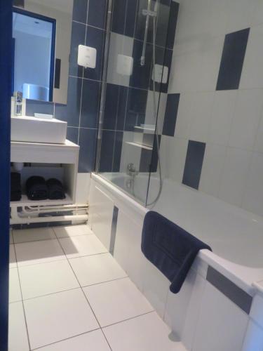 une salle de bain avec une baignoire et un lavabo dans l'établissement Appartement village 9 en résidence de vacances en Camargue, à Arles
