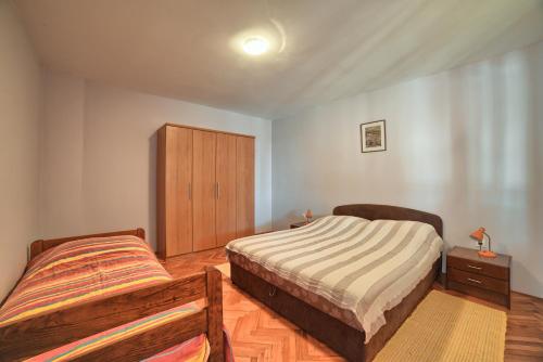 a bedroom with two beds and a wooden cabinet at Apartment Villa Mare1 with pool, sea view and hydromassage in Banjole