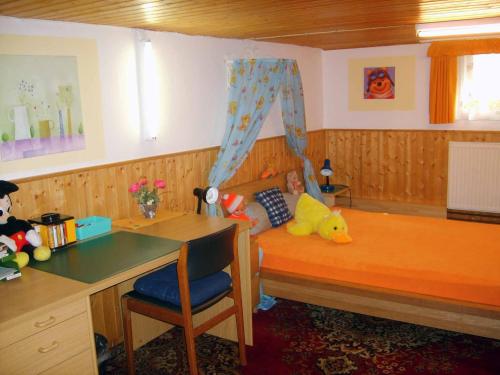 a child sitting on a bed in a doll house at Ferienhaus Baumann in Neukirchen beim Heiligen Blut