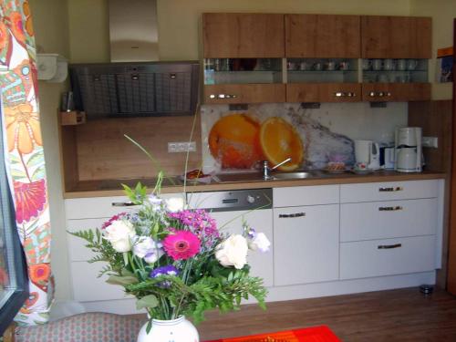 a kitchen with a vase of flowers on a table at Ferienhaus Baumann in Neukirchen beim Heiligen Blut