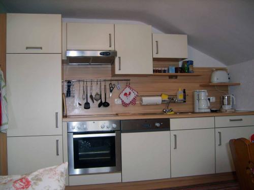 a kitchen with white cabinets and an oven at Ferienhaus Baumann in Neukirchen beim Heiligen Blut