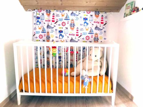 a white crib with a stuffed animal in it at Ferienhaus Baumann in Neukirchen beim Heiligen Blut