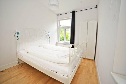a white bed in a white room with a window at White Sand Apartment Centrum by Grand Apartments in Sopot
