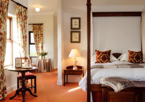 una camera con letto e tavolo con lampada di Lough Inagh Lodge Hotel a Recess