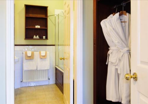 a bathroom with a shower and a robe on a door at Lough Inagh Lodge Hotel in Recess