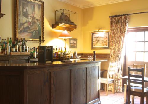 a bar with a wooden counter in a room at Lough Inagh Lodge Hotel in Recess
