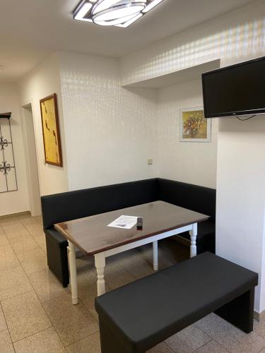 a room with a table and a bench and a tv at Ferienwohnungen Rehn in Dresden