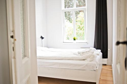 two beds in a room with a window at White Rock Apartment by Grand Apartments in Sopot