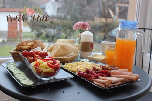 a tray of food with cheese and fruit on a table at Boutique Vendégház Vidéki Idill Noszvaj in Noszvaj