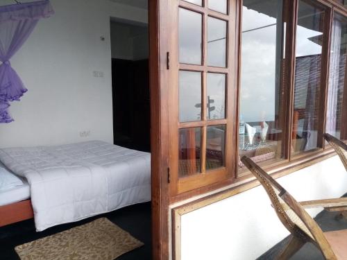 a room with a bed and a glass door with a window at Il Villino haputale in Haputale