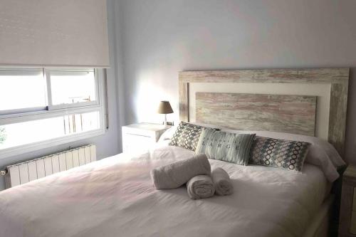 - une chambre avec un lit blanc et des serviettes dans l'établissement Apartamento Can CALET con PARKING en Sant Antoni de Calonge, à Calonge