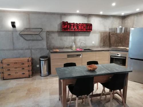 a kitchen with a table with chairs and a refrigerator at Domaine de la Vidalle in Vendres